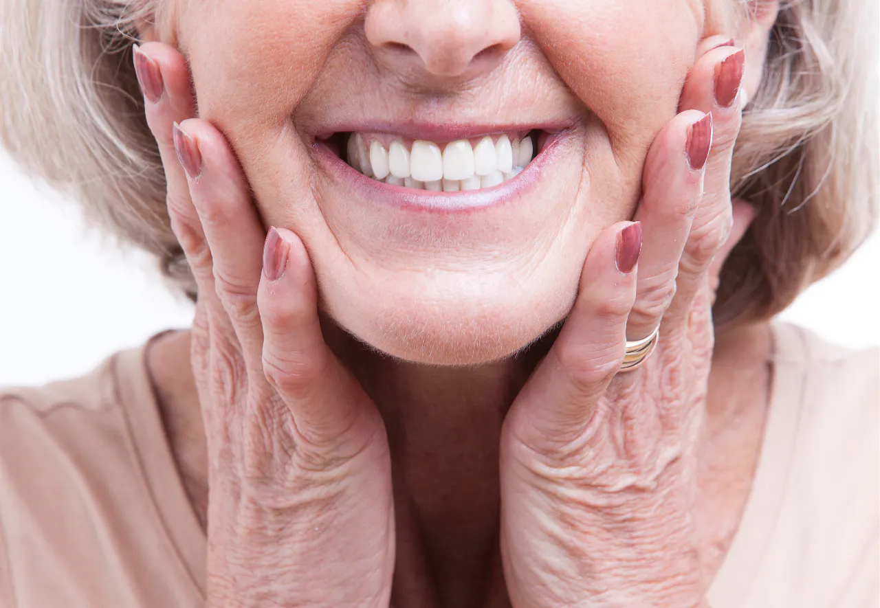A patient smiling confidently with her new custom dentures