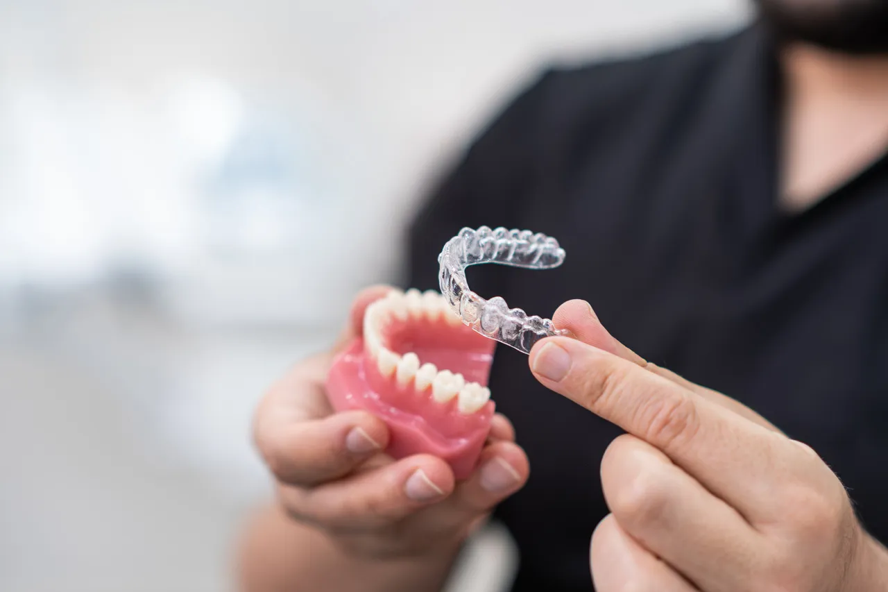 A clear aligner tray for straightening teeth